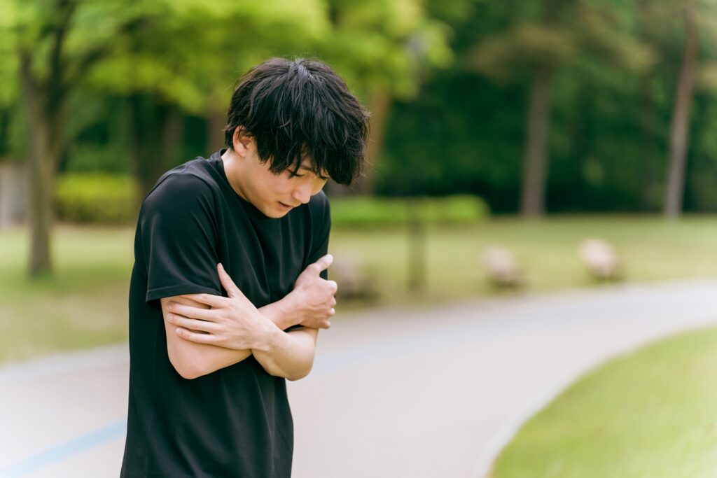 寒そうな男性　黒い服