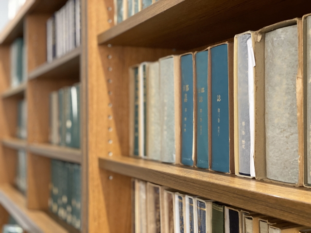 木の本棚に並ぶ専門書で知識を深める